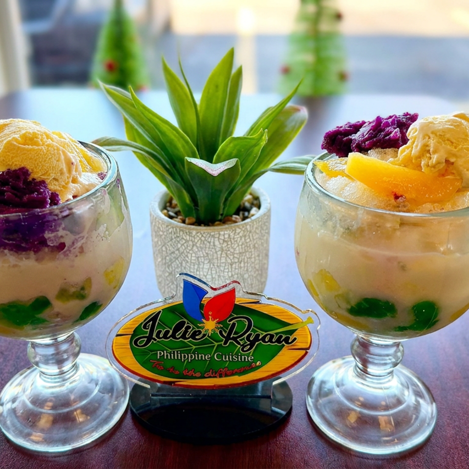 Two Filipino-style shaved ice desserts topped with purple yam, mango, and ice cream beside a plant and Jabe Ryan Philippine Cuisine sign.